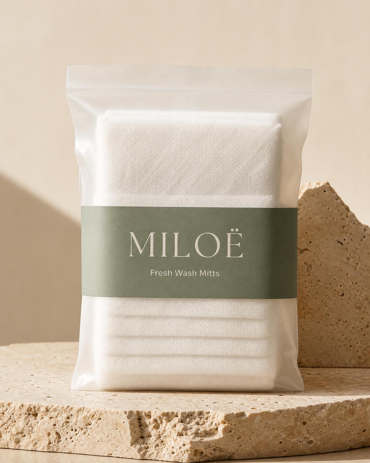 Pochette MILOË Fresh Wash Mitts, gants de toilette blancs sur pierre travertin